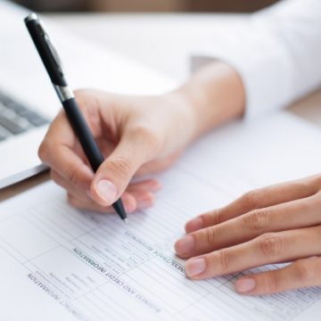 closeup-of-business-person-completing-form_1262-2254