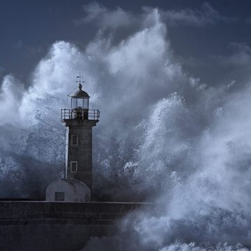 Big stormy sea wave splash over old Oporto lighthouse. Douro river mouth. Infrared.